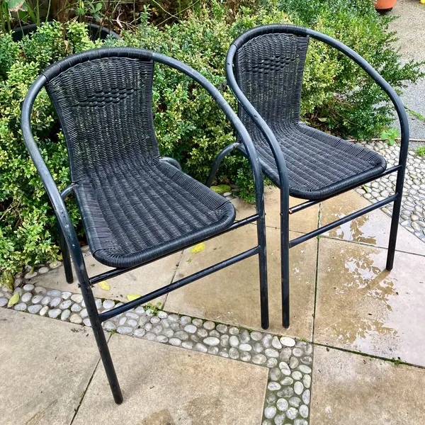 Two black outdoor stacking bistro chairs