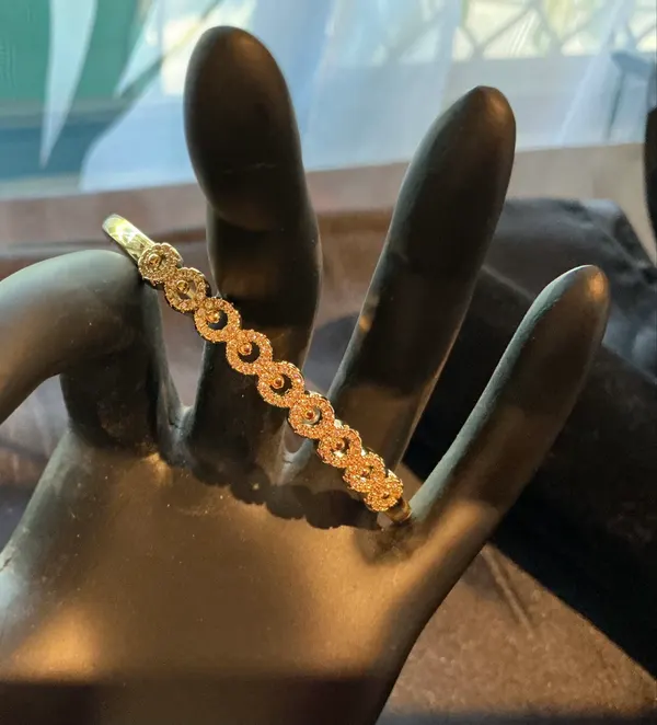 Gold tone stainless steel crystal hinged bangle bracelet