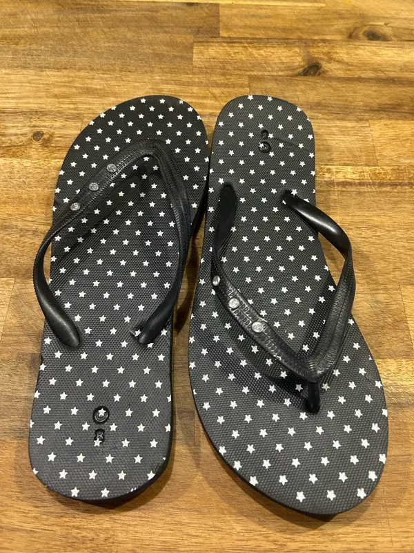 Women’s black star print flip flops
