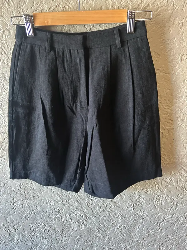 Lily loves black pleated Bermuda shorts